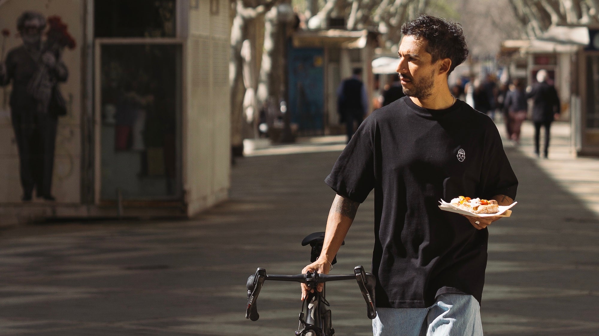 A cyclist walking down the street in an Angry Pablo t-shirt