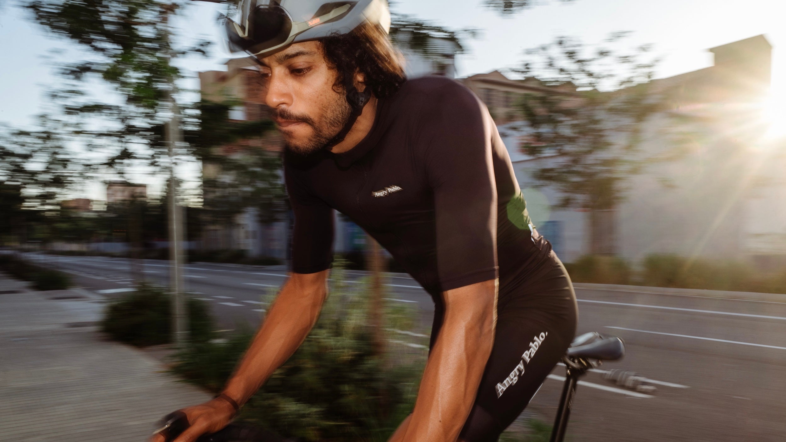 A cyclist wearing Angry Pablo clothing riding in the evening