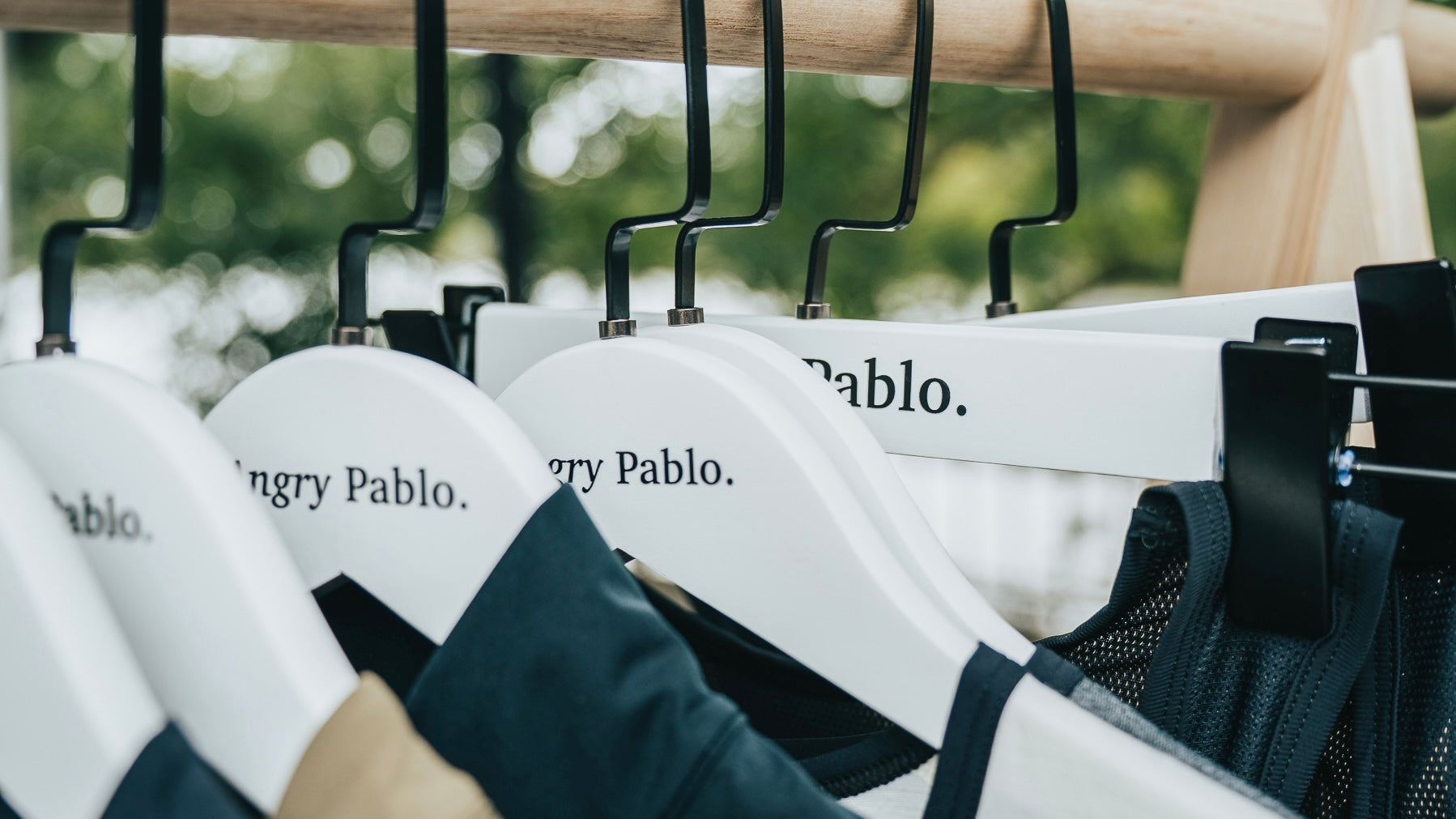Angry Pablo cycling products hanging on clothes hangers