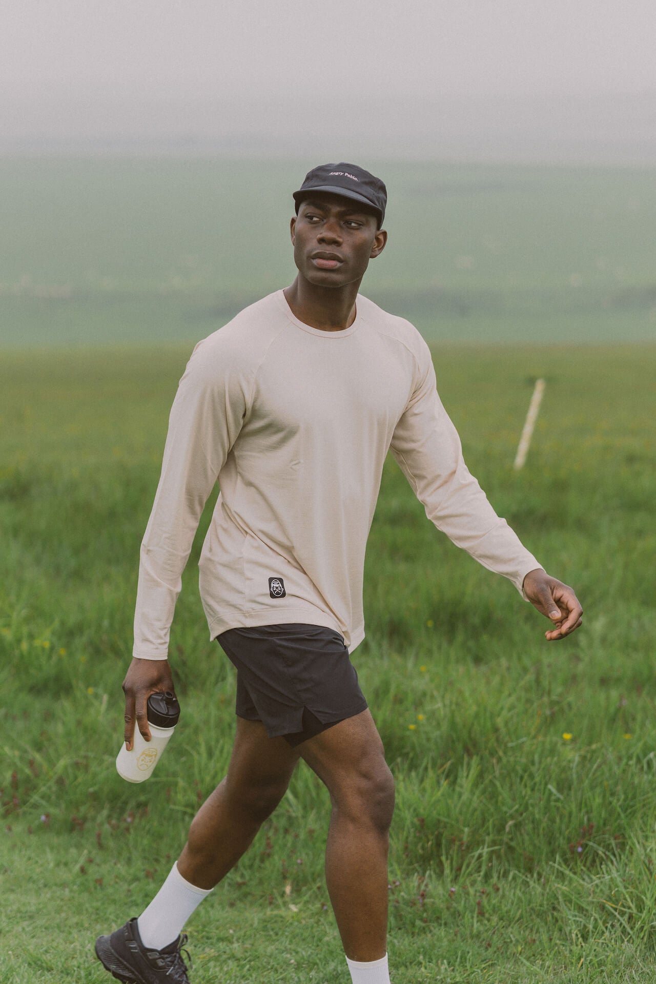 a man walking through a field in angry pablo activewear